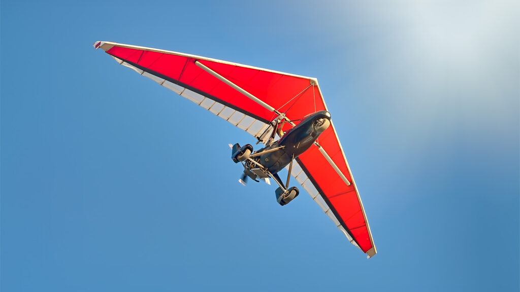 ultralight motorized aircraft in a blue sky