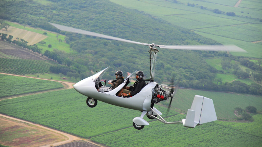 Autogyro flying over the tropical landscape