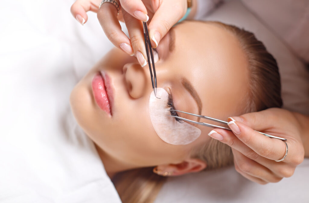 Eyelash Extension Procedure. Woman Eye with Long Eyelashes. Lashes. Close up, selected focus.