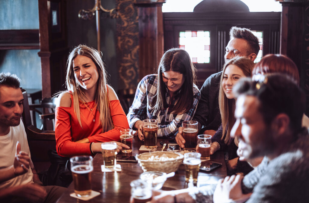 people talking indoors in a pub with the beers