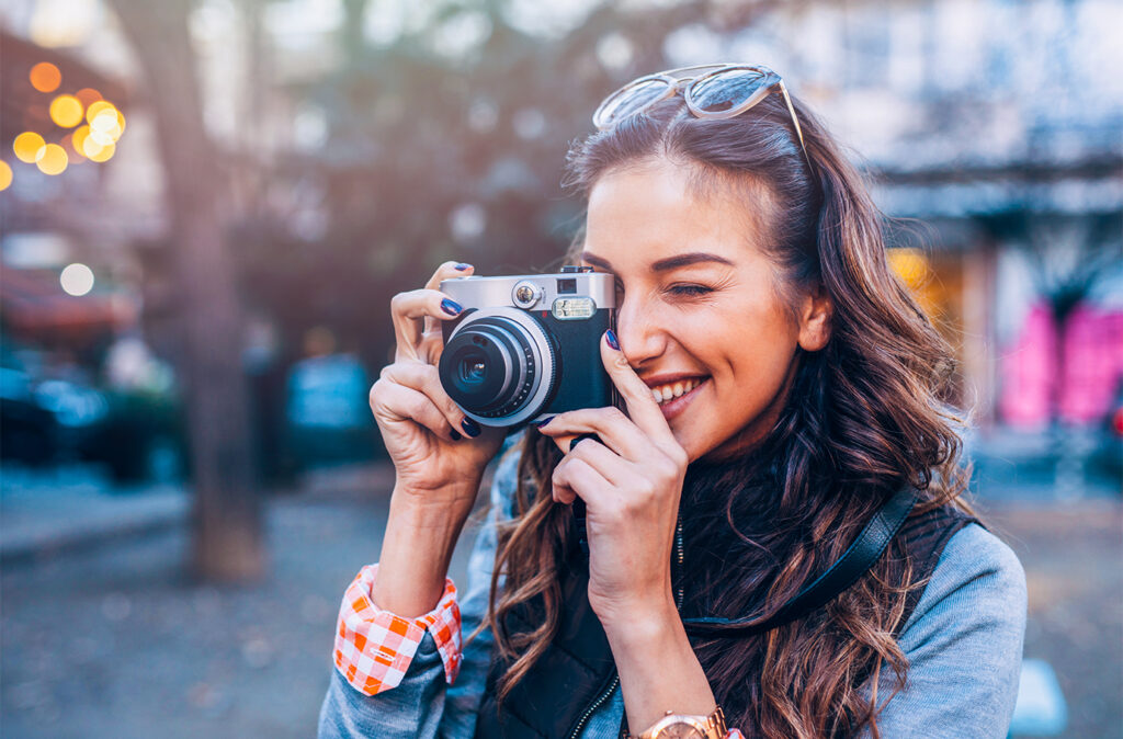 Young female photographer  taking pictures outdoors.