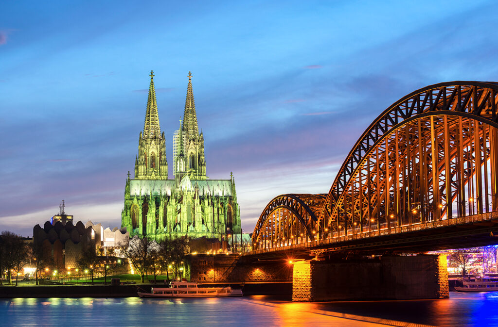 Cologne cathedral and the Hohenzollern Bridge on the Rhein river at twilight, Germany