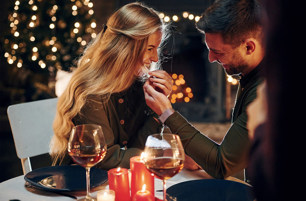 Side view. Young lovely couple have romantic dinner indoors together.