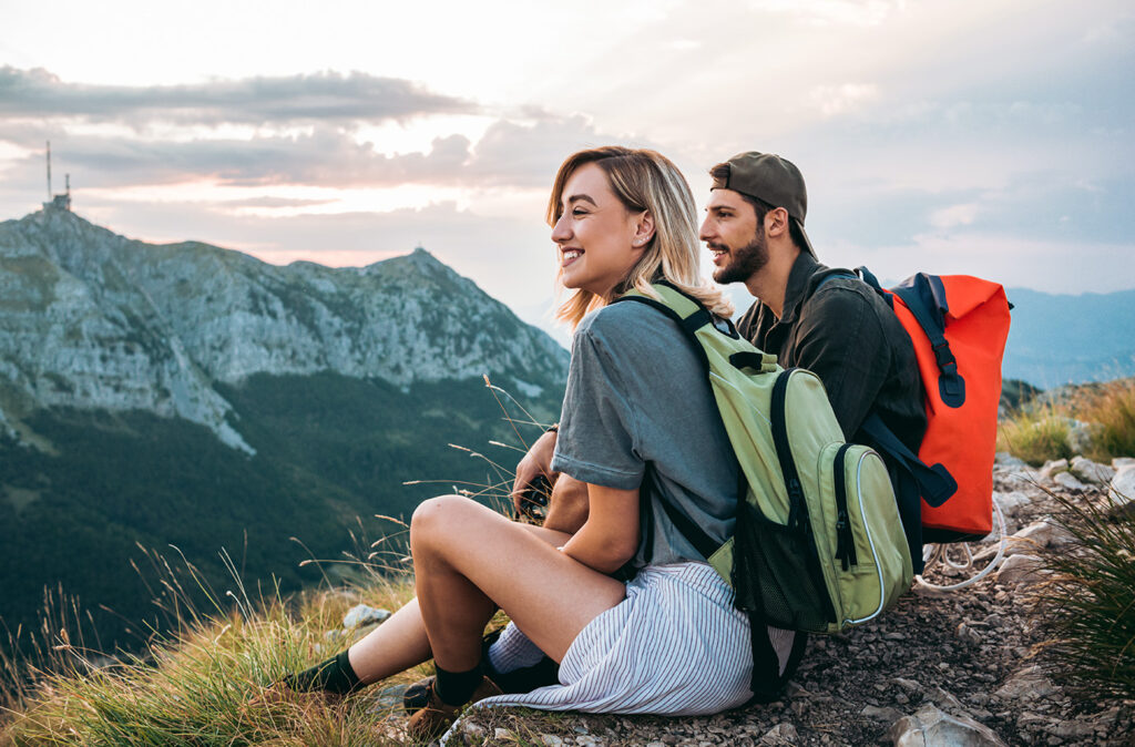 young couple of hikers enjoying the beautiful nature from high above