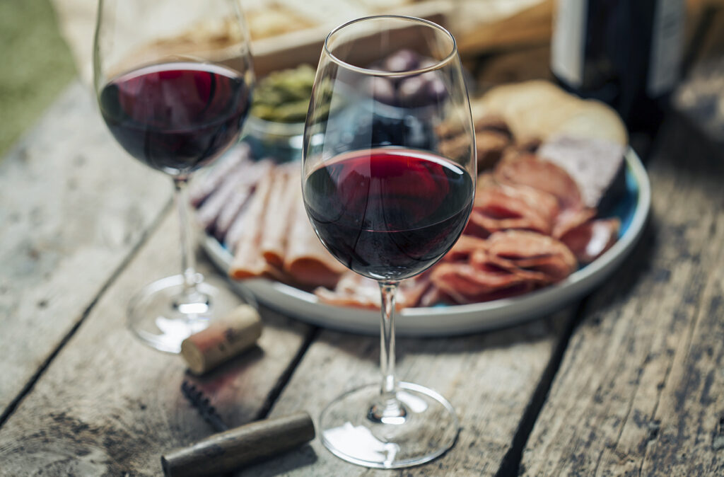 Red wine with charcuterie assortment on the background