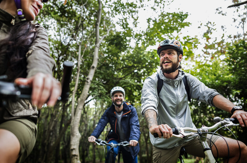 Group of friends ride mountain bike in the forest together