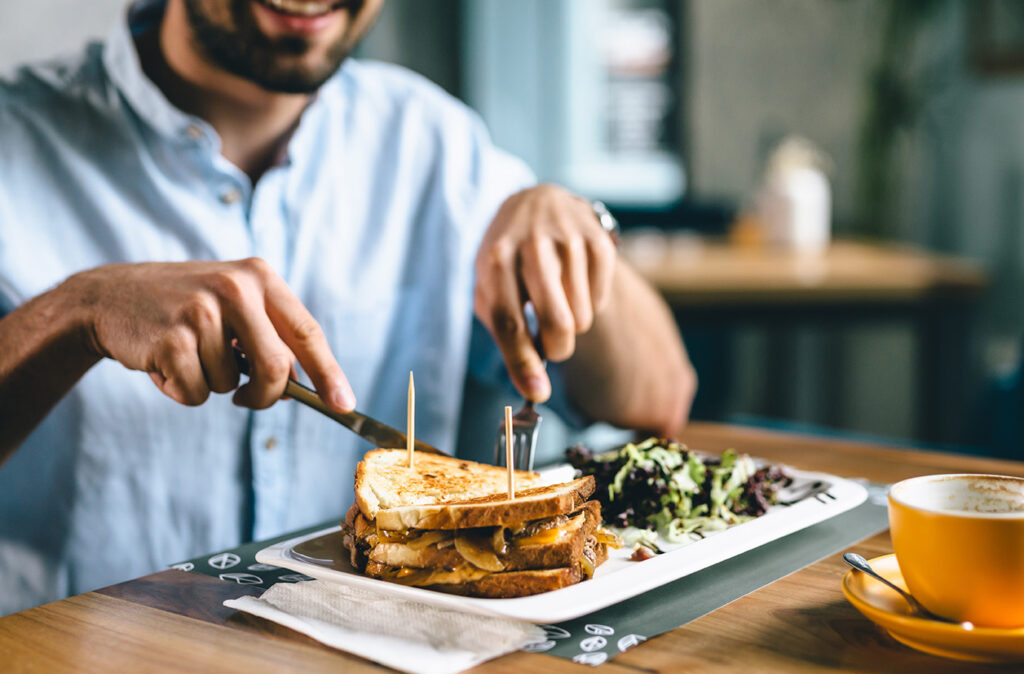 close up of man having dinner or breakfast in restaurant