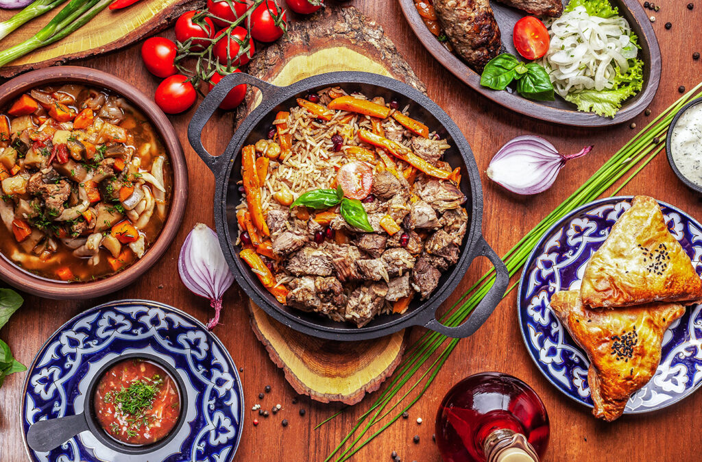 Traditional Uzbek oriental cuisine. Uzbek family table from different dishes for the New Year holiday. The background image is a top view.