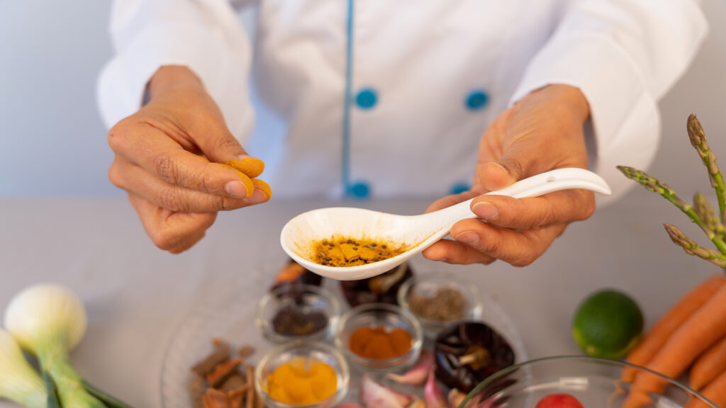 Chefs hands manipulating and observing the colors and textures of spices in the kitchen of her restaurant