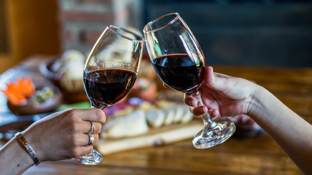 Toast with wine, with the background of a traditional finger food table