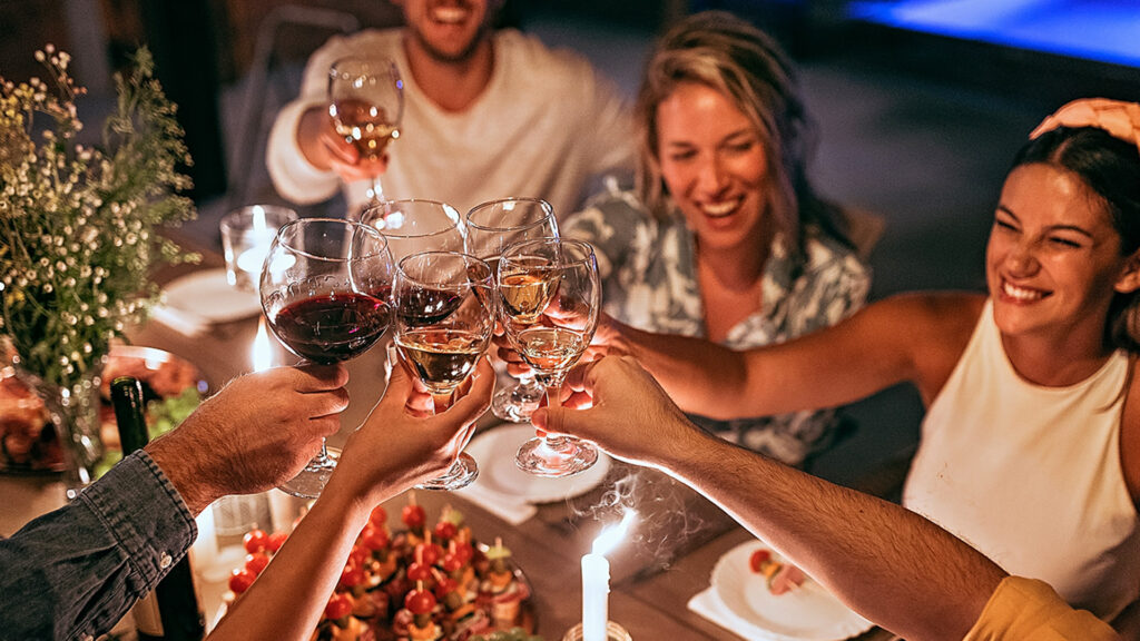 Group of friends having dinner party in backyard/holiday villa