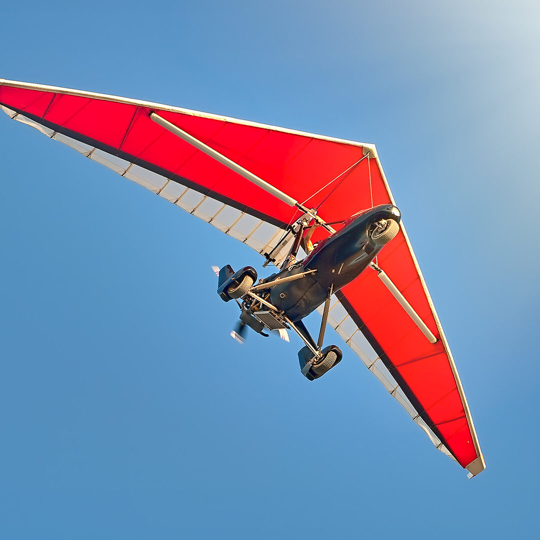 ultralight motorized aircraft in a blue sky