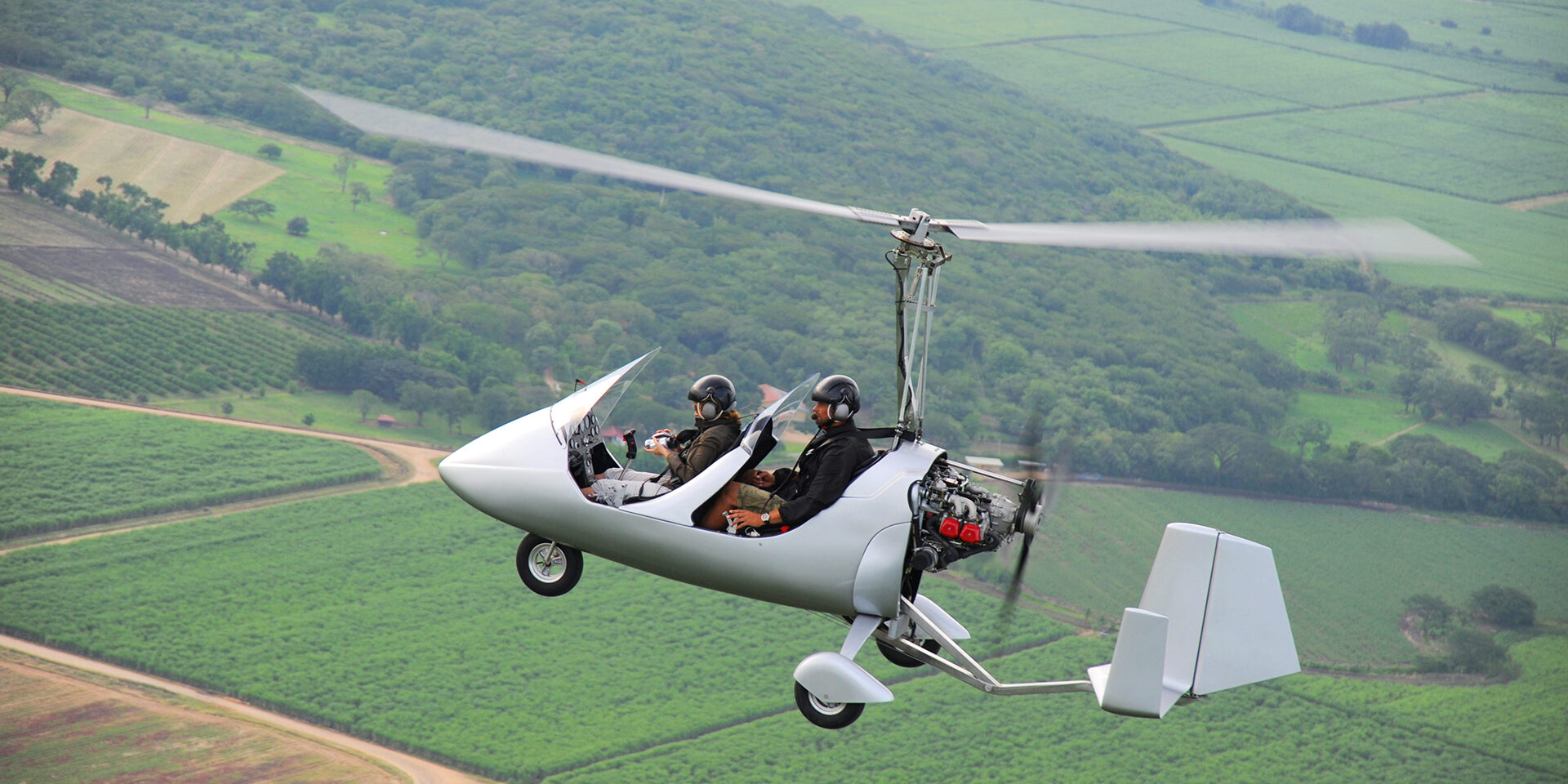 Autogyro flying over the tropical landscape