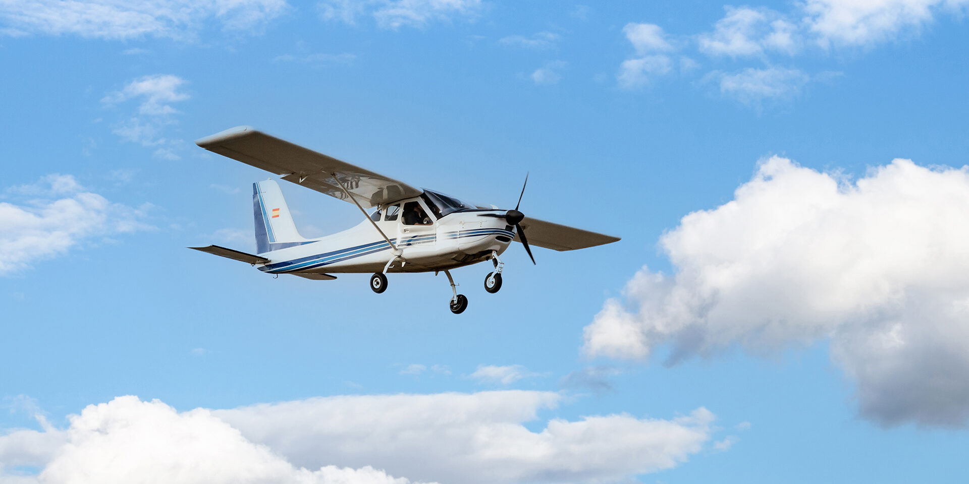 Light aircraft flying over blue sky Single engine ultralight plane flying in the blue sky with white clouds