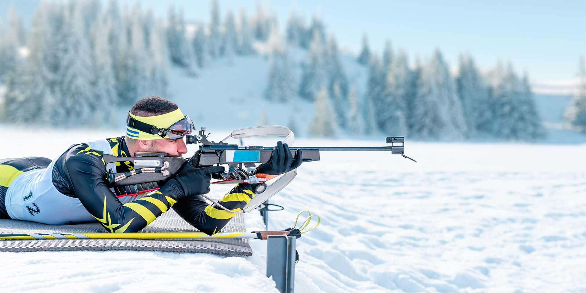 Biathlete shoots in the prone position on training ground Biathlete shoots in the prone position on training ground