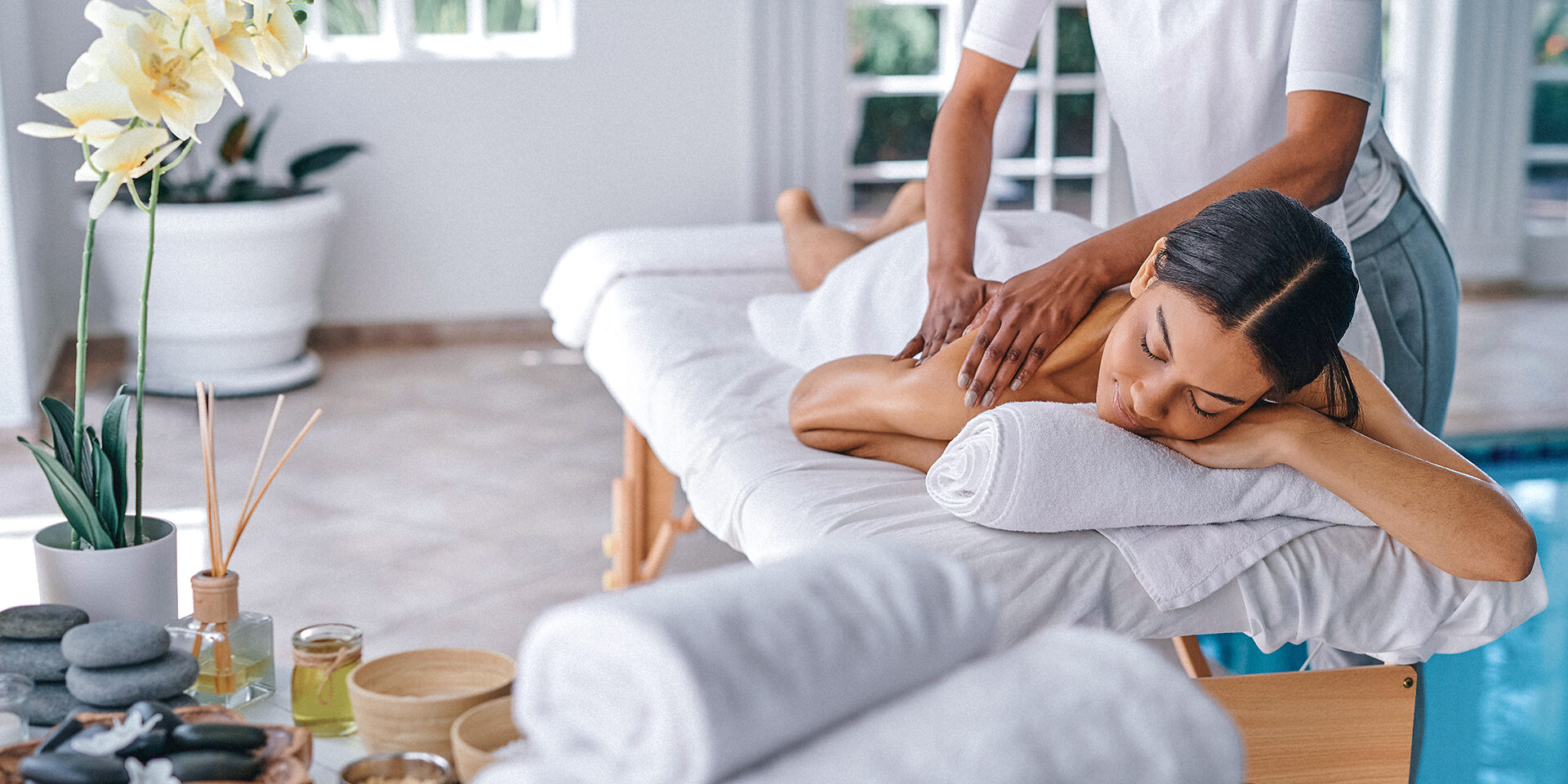 Full length shot of an attractive young woman lying on a bed and enjoying a massage at the spa Goodbye knots
