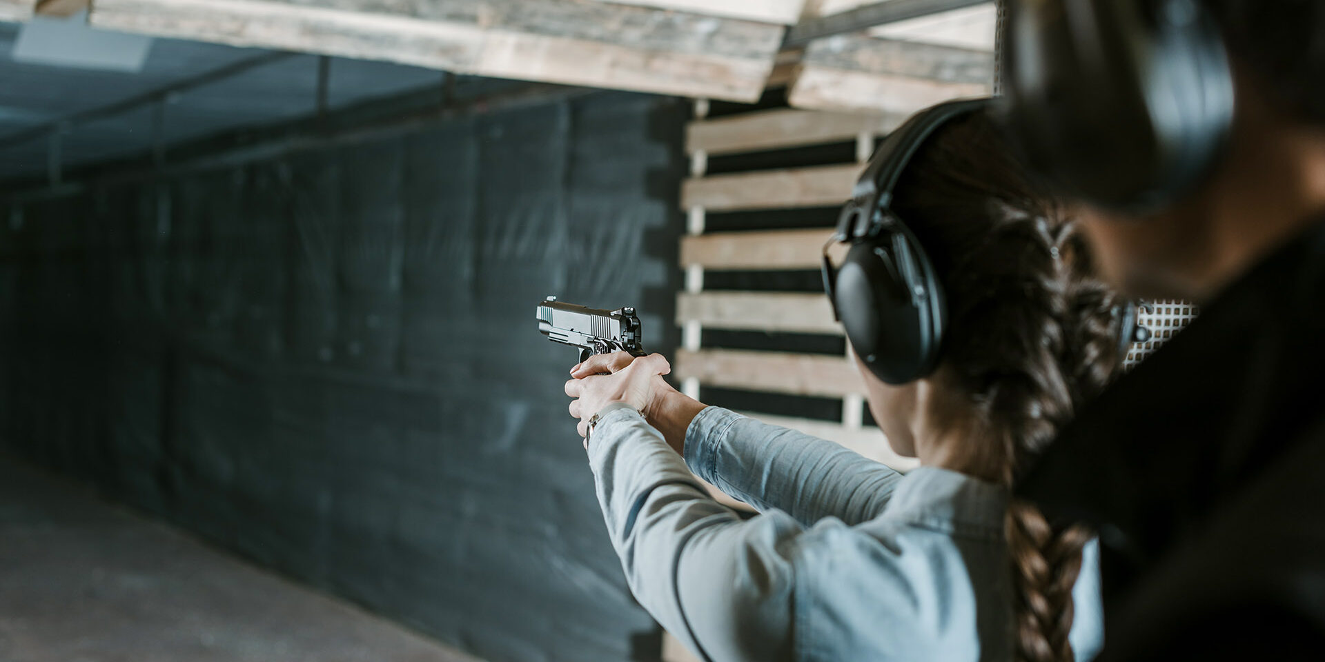rear view of girl shooting with gun in shooting gallery rear view of girl shooting with gun in shooting gallery