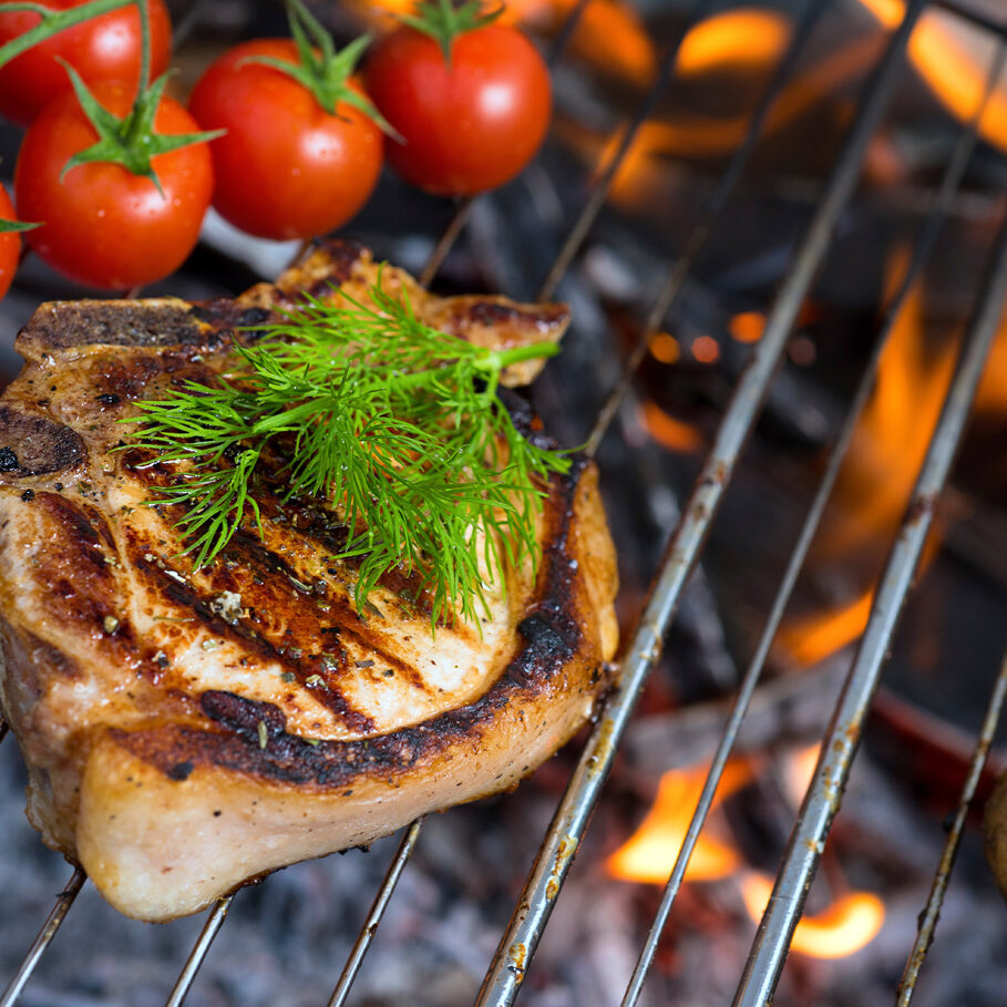 Stake grill and tomatoes with flame on background