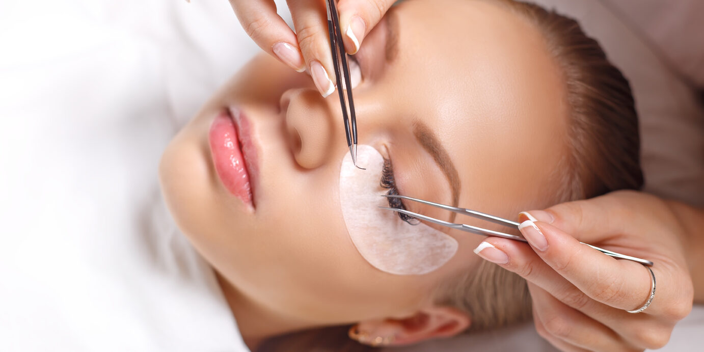 Eyelash Extension Procedure. Woman Eye with Long Eyelashes. Lashes. Close up, selected focus.