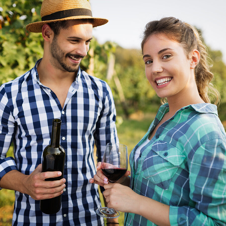 Couple tasting wine in vineyard