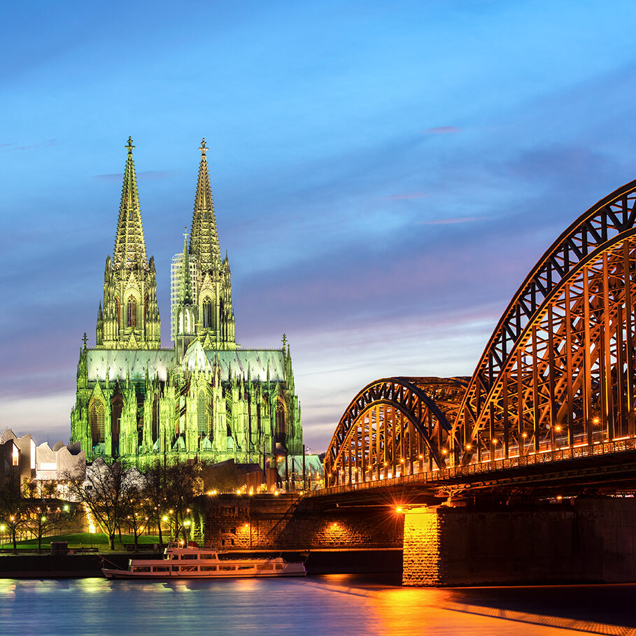 Cologne cathedral and the Hohenzollern Bridge on the Rhein river at twilight, Germany