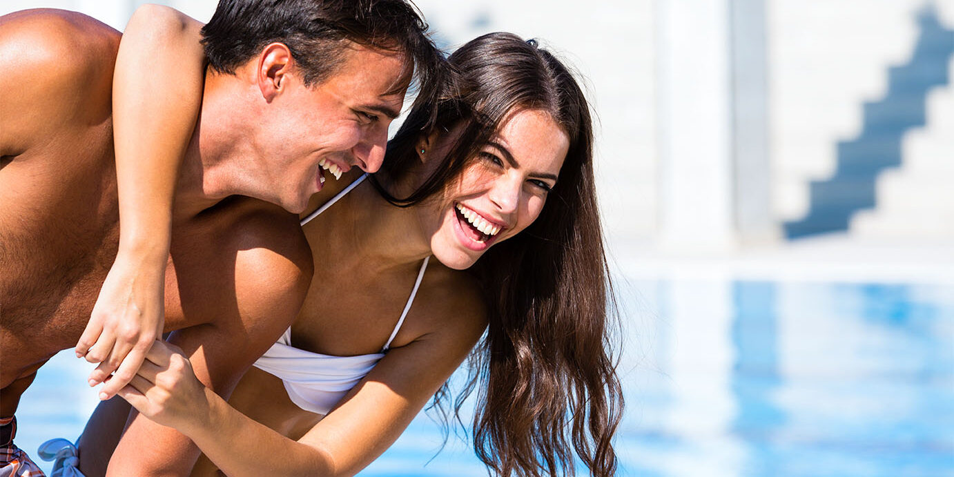 Young man and woman having fun by the swimming pool.