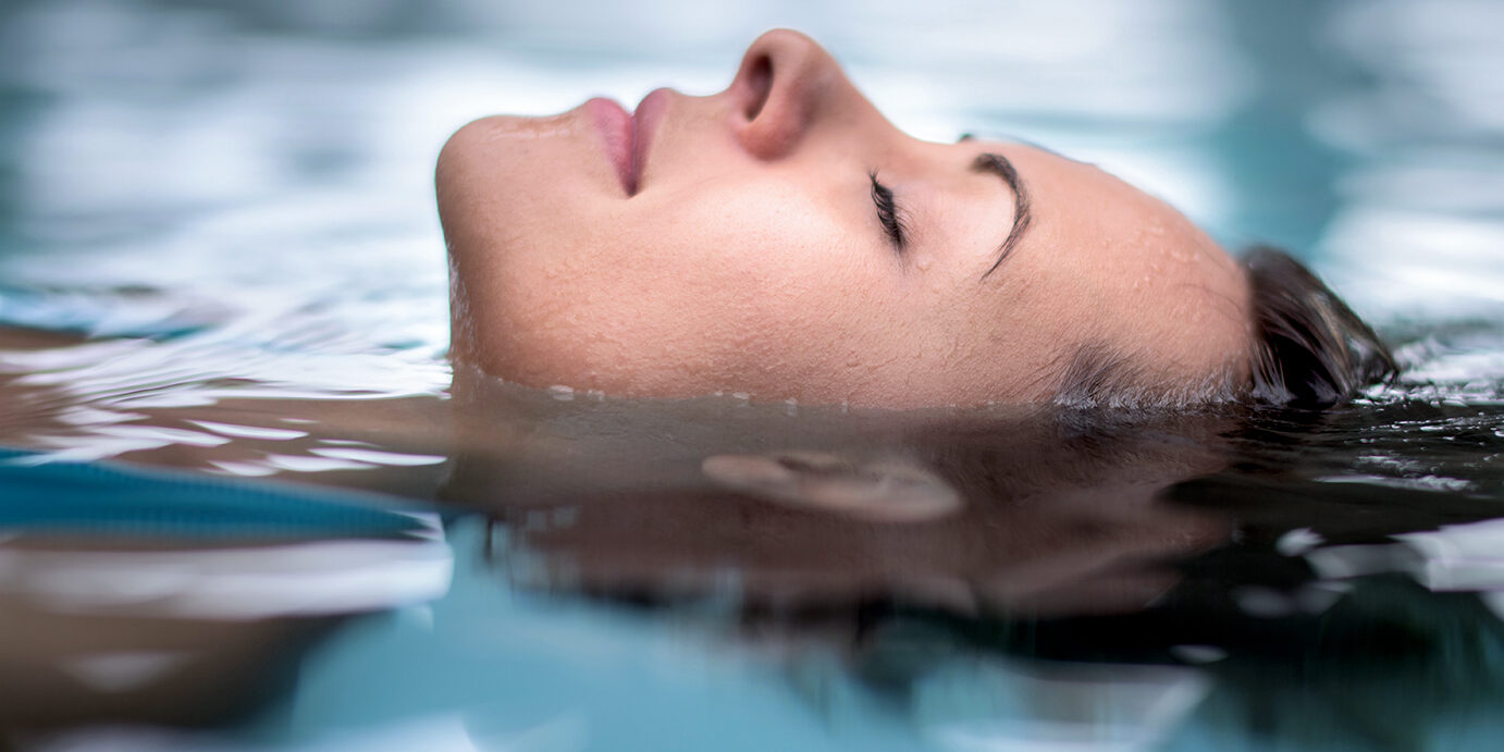 Woman at the spa relaxing at the swimming pool Woman at the spa relaxing at the swimming pool floating with eyes closed