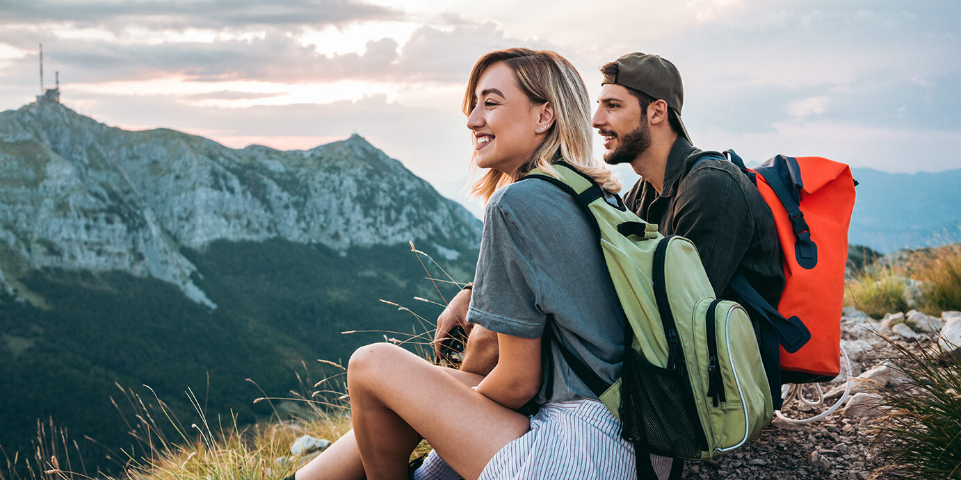 young couple of hikers enjoying the beautiful nature from high above