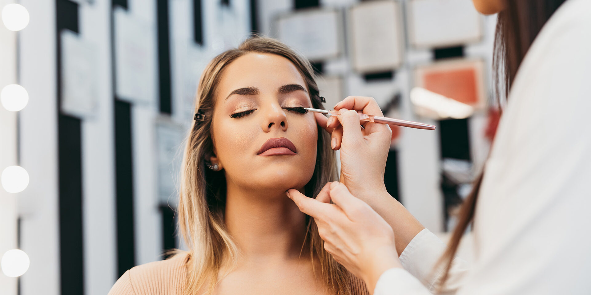 Professional makeup artist at work Professional makeup artist doing professional make up of beautiful young woman.