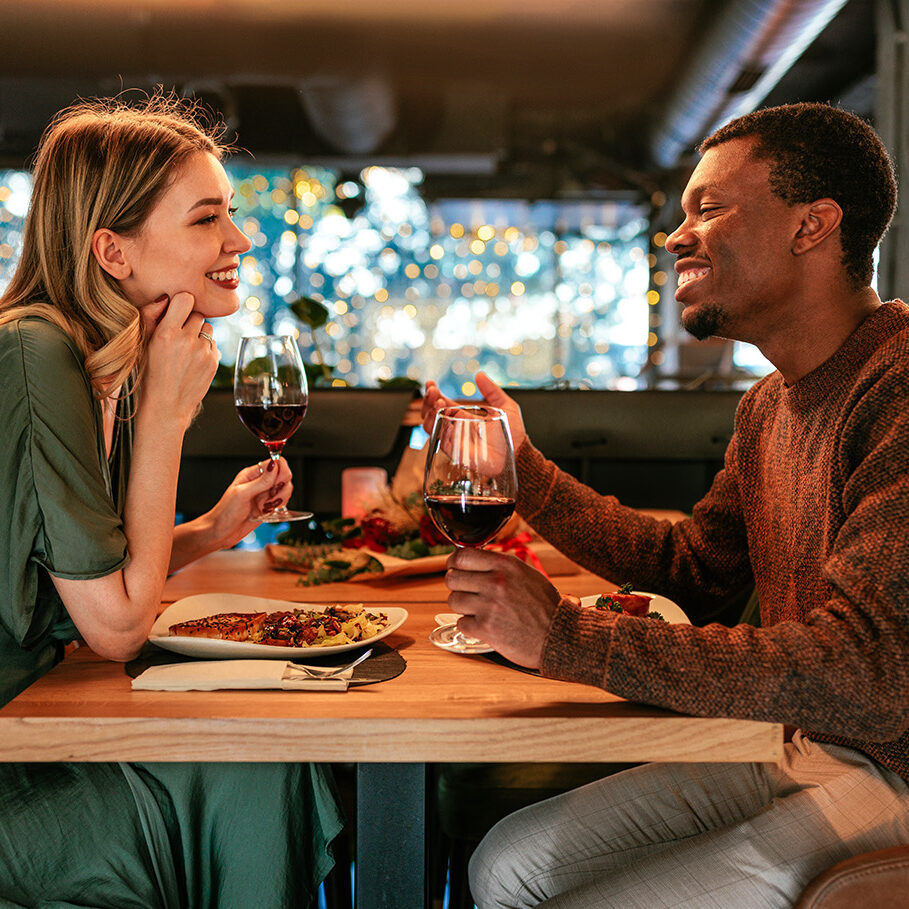 A happy young couple is on a Valentines day dinner date in a fancy restaurant.