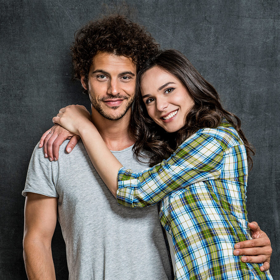 Portrait Of Beautiful Young Couple Over Blackboard