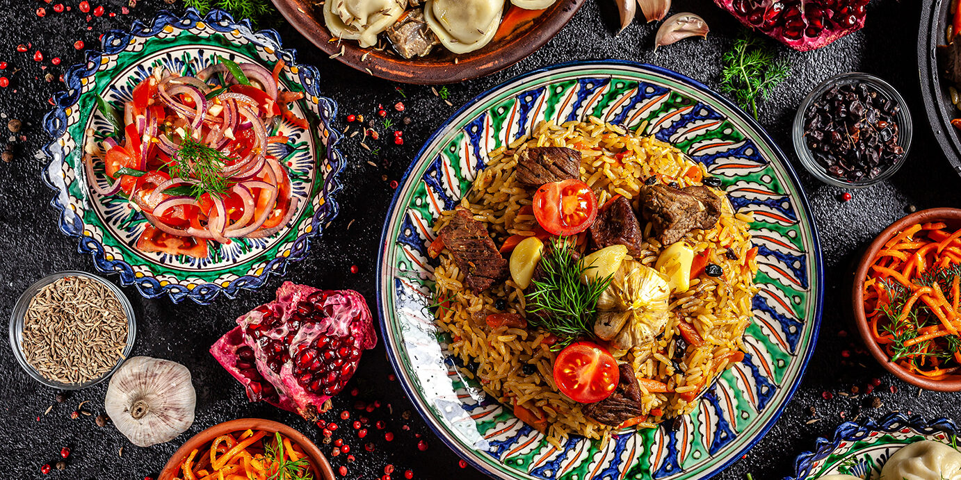 Traditional Uzbek oriental cuisine. Uzbek family table from different dishes in national dishes for the New Year holiday. The background image is a top view, copy space, flat lay Traditional Uzbek oriental cuisine. Uzbek family table from different dishes in national dishes for the New Year holiday. The background image is a top view, copy space, flat lay