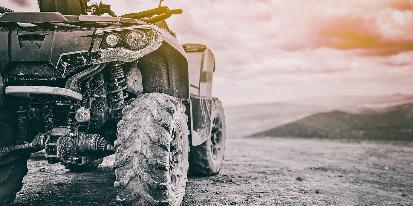 Quadricycle or quad bike on the mountains background on a cloudy day in black and white toned Quadricycle or quad bike on the mountains background