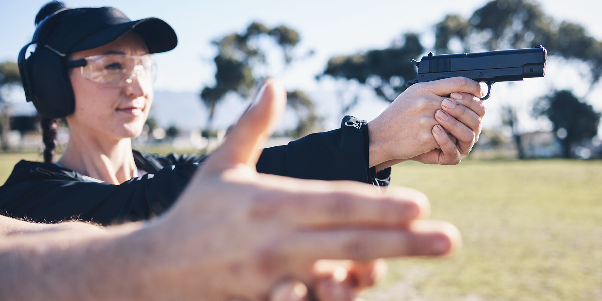 Man, woman and gun training with aim, outdoor target or hand position at police, army or security academy. Shooting coach, pistol or firearm for sport, safety or combat exercise in nature for vision Man, woman and gun training with aim, outdoor target or hand position at police, army or security academy. Shooting coach, pistol or firearm for sport, safety or combat exercise in nature for vision
