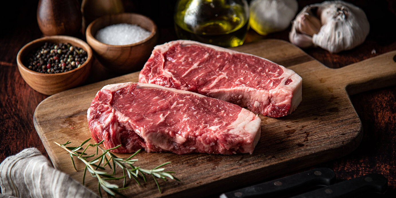 raw strip beef steak meat on wooden cutting board raw strip beef steak meat on wooden cutting board