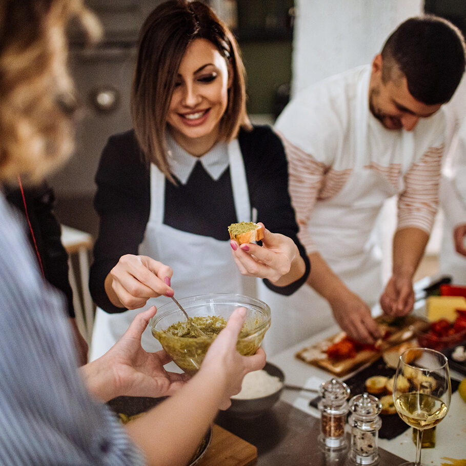 Photo of a young woman in a kitchen during a cooking class, preparing bruschetta