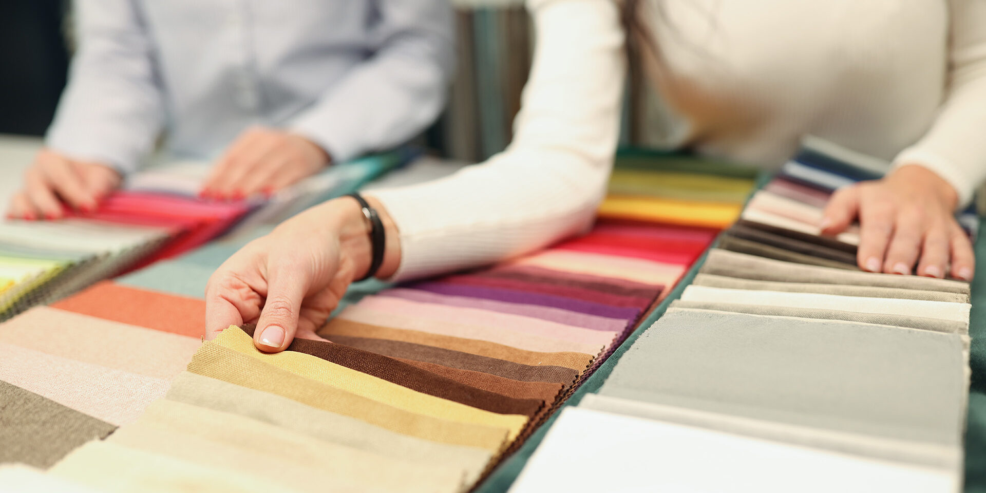Buyer and seller choose color of fabric closeup Buyer and seller choose color of fabric. Custom tailoring concept