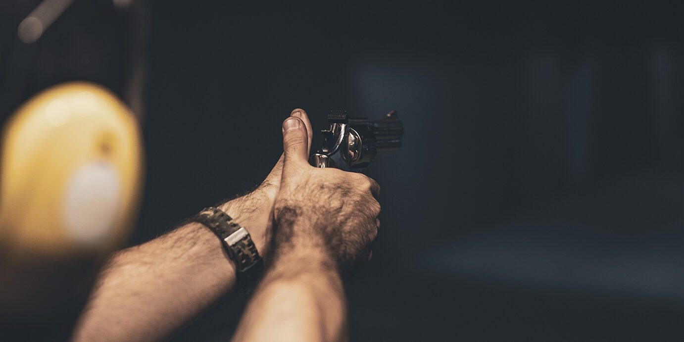 Shooting with Gun at Target in Shooting Range Shooting with Gun at Target in Shooting Range on men hand