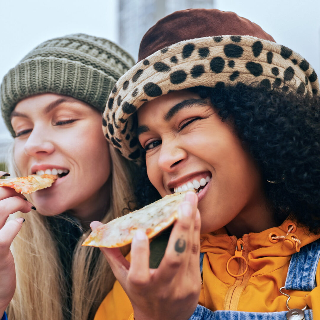 Selfie, young women and friends with food portrait with funny face and playful picture, smile and happy outdoor. Gen z youth, friendship and silly pose with pizza for photo and social media content.