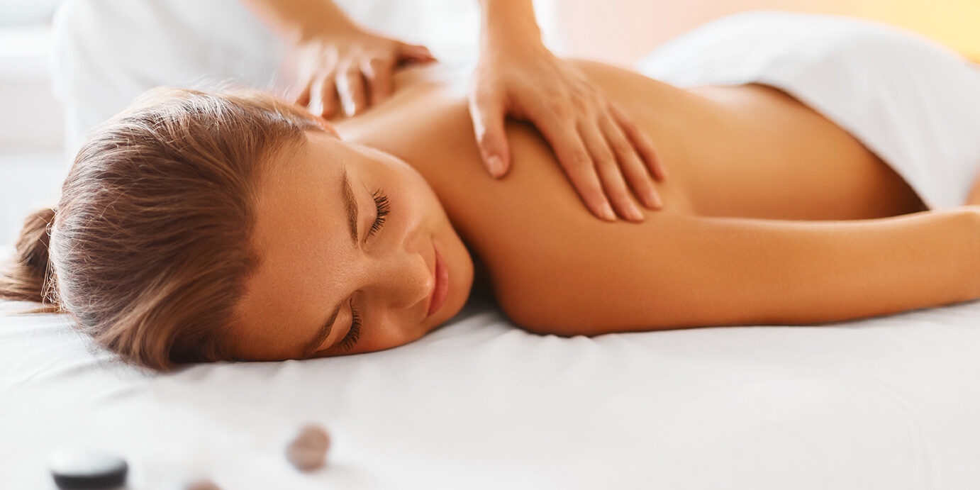 Spa Woman. Female Enjoying Massage in Spa Centre. Spa woman. Female enjoying relaxing back massage in cosmetology spa centre. Body care, skin care, wellness, wellbeing, beauty treatment concept.