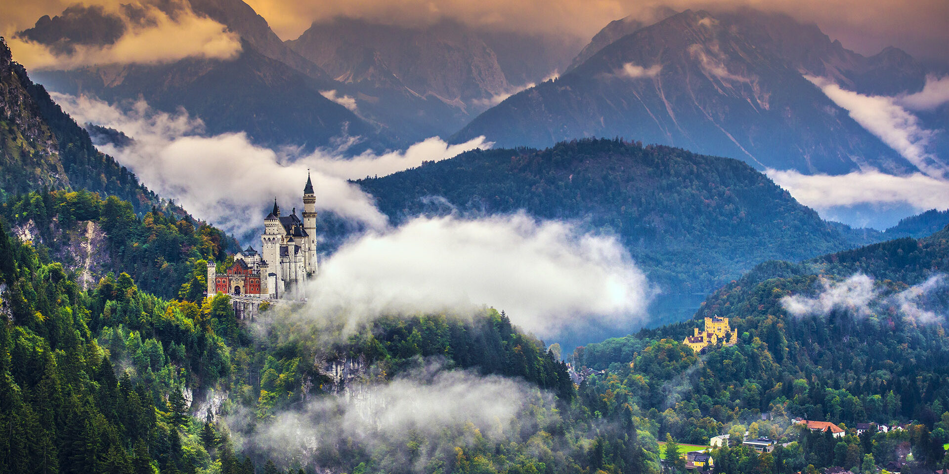 Wide-view of magnificent Neuschwanstein Castle in mountains Neschwanstein Castle in the Bavarian Alps of Germany.