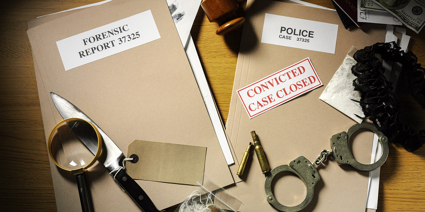 Case Closed with Police Files and Forensic Paperwork Police handcuffs, Knife and bullets on a desk with forensic and police paper files with a gavel and mallet, magnifying glass, currency and drugs. Case closed...