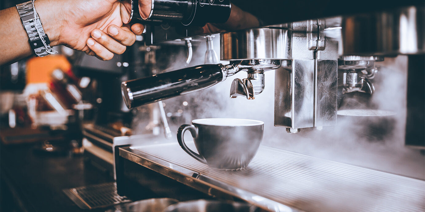 Barista making fresh coffee with machine in coffee shop or cafe.