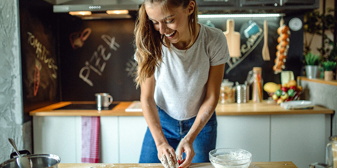 Woman preparing dought for pizza Woman in kitchen preparing dough for pizza