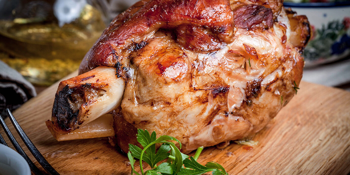 Roast pork knuckle on a wooden board. Selective focus.