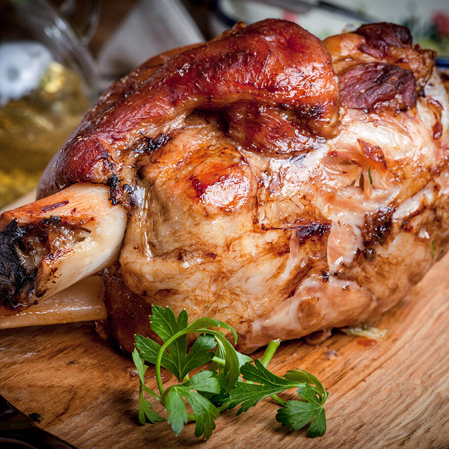 Roast pork knuckle on a wooden board. Selective focus.