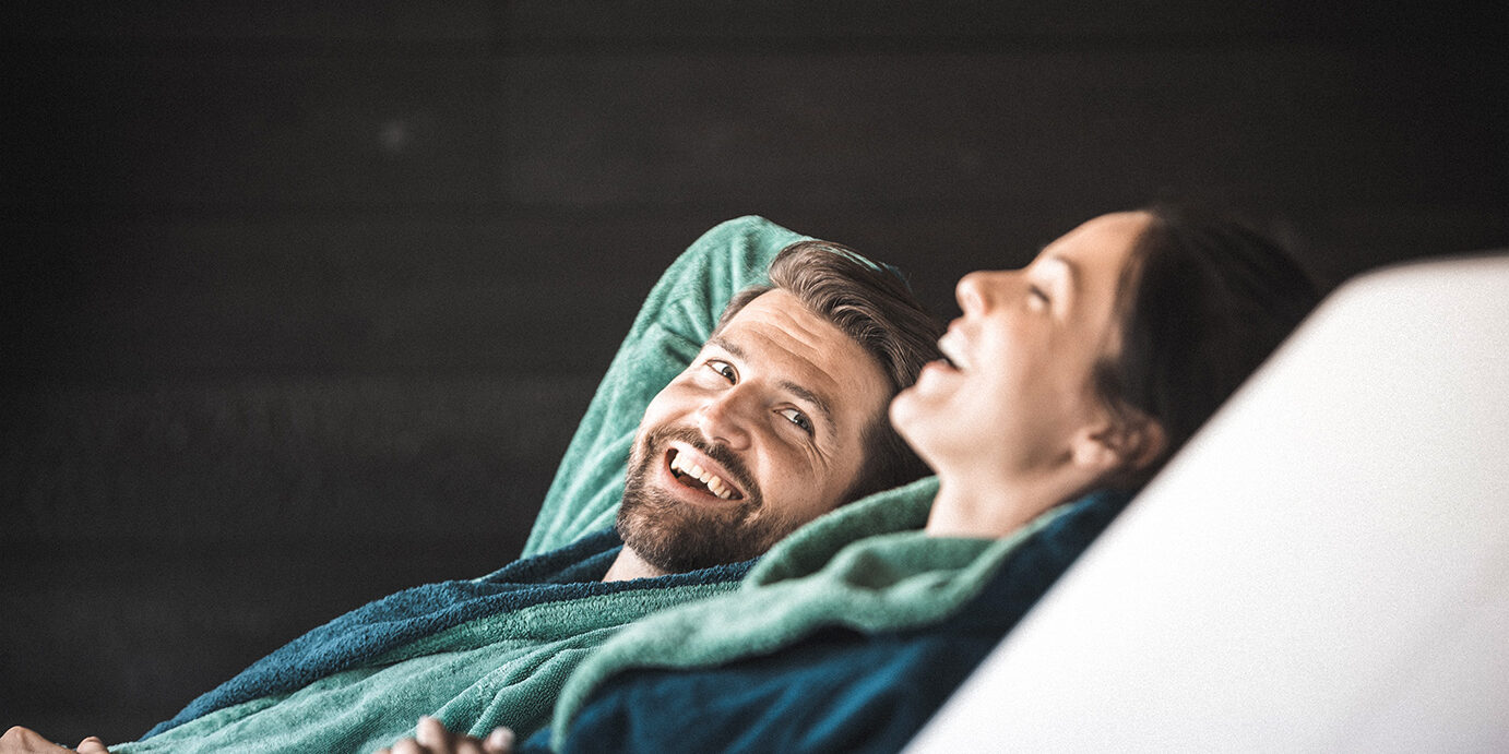 A couple sitting on lounge chairs in a wellness hotel. They are relaxing.