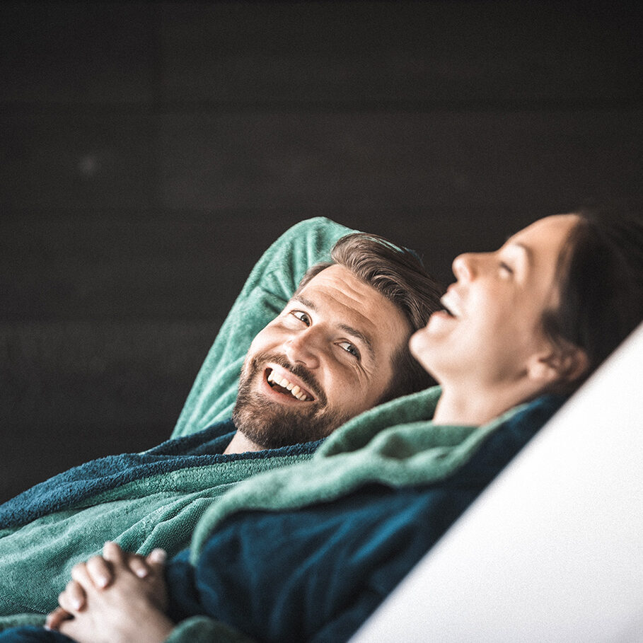 A couple sitting on lounge chairs in a wellness hotel. They are relaxing.