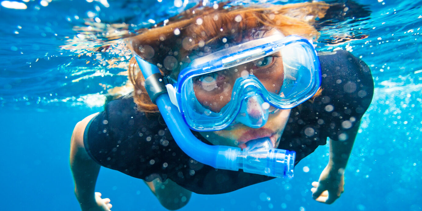 young woman snorkeling underwater young woman snorkeling in clean waters of Indian ocean