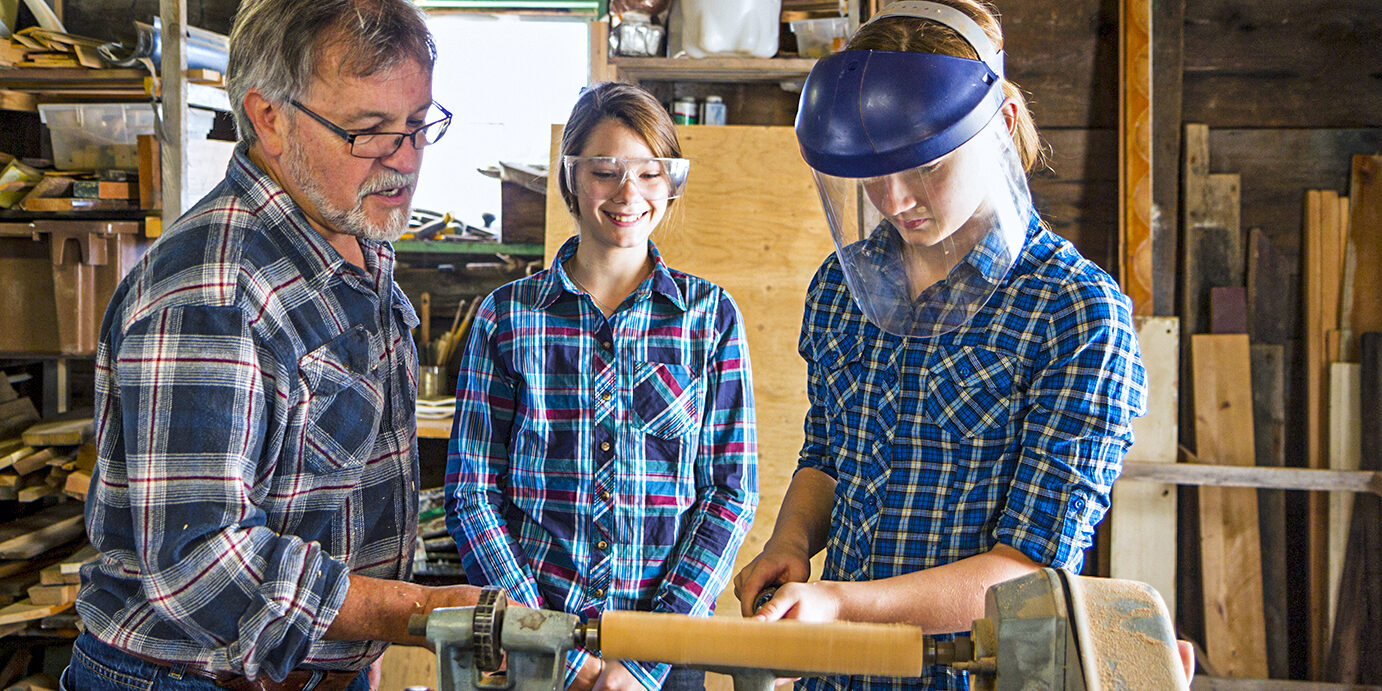 Teacher Showing Students How To Use A Lathe Teacher Showing Students How To Use A Lathe